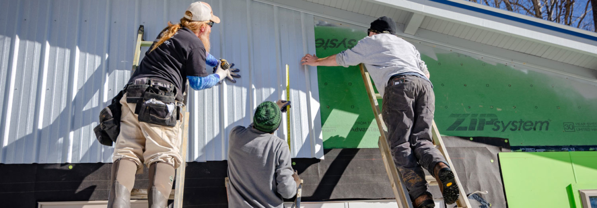 Contractors install siding