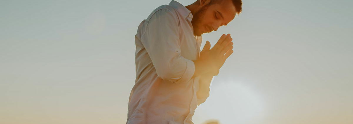 man praying on top of mountain