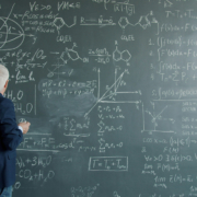 complexity man standing in front of a busy chalkboard
