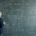 man standing in front of a busy chalkboard