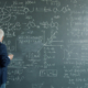 man standing in front of a busy chalkboard