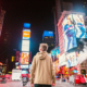 man stares up at advertising billboards