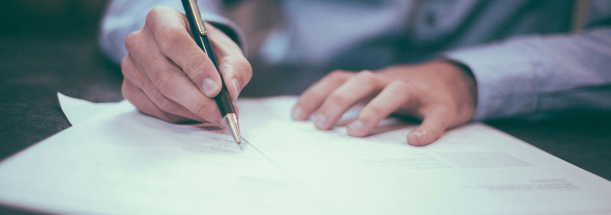 man writing on paper
