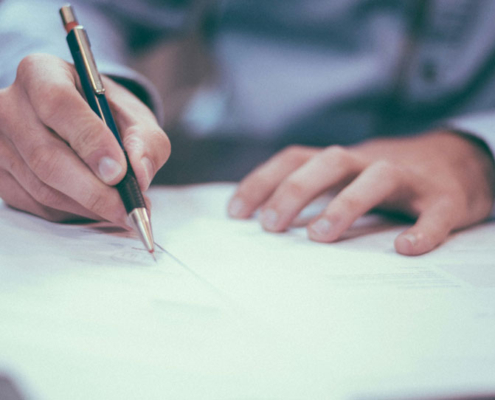 man writing on paper