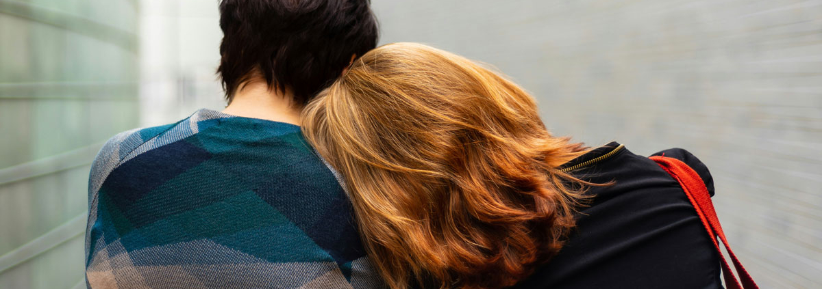 a woman leans on someones shoulder