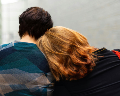a woman leans on someones shoulder