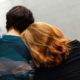 a woman leans on someones shoulder