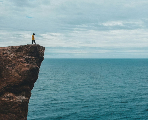 man staring over edge of cliff