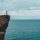 man staring over edge of cliff