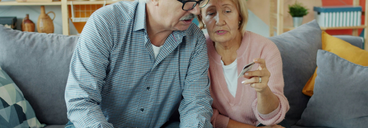 an elderly couple examines a credit card