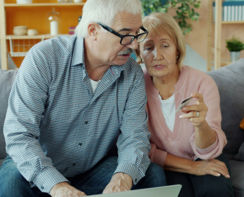an elderly couple examines a credit card