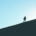 man silhouetted climbing a mountain